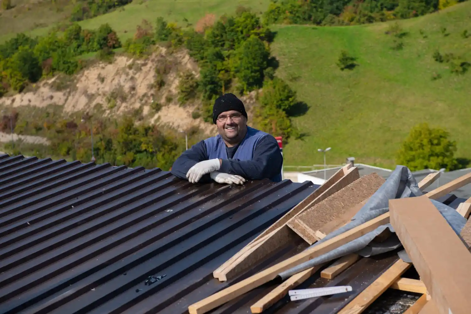 Contractor replacing broken roof shingles on residential property