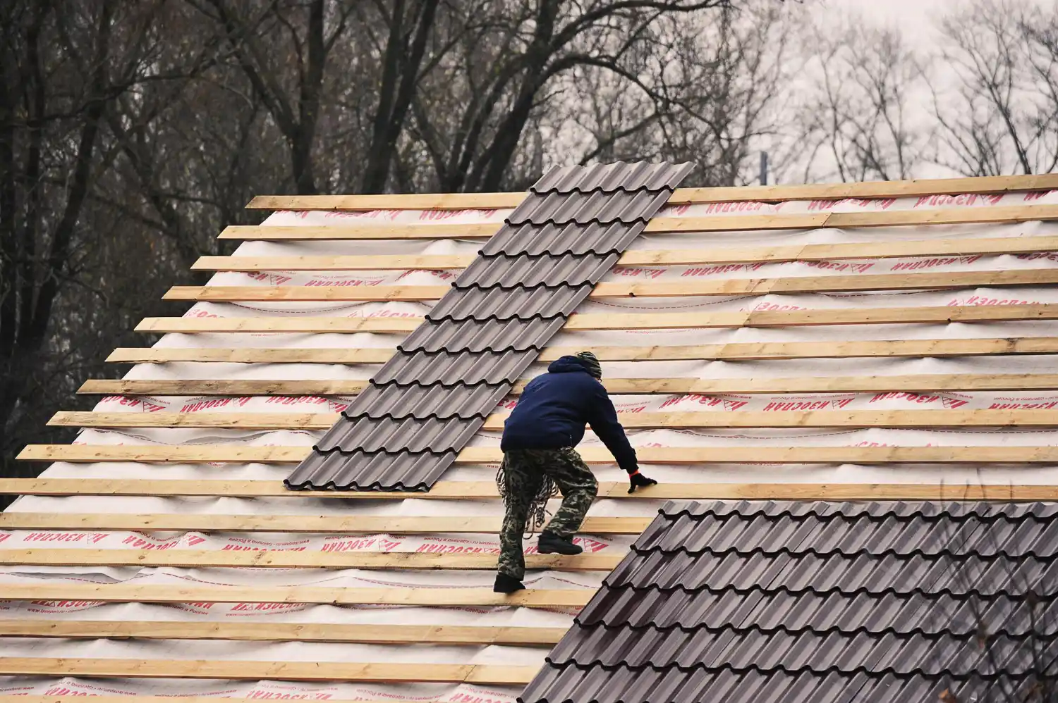 Roofing specialist inspecting damaged shingles and roof structure