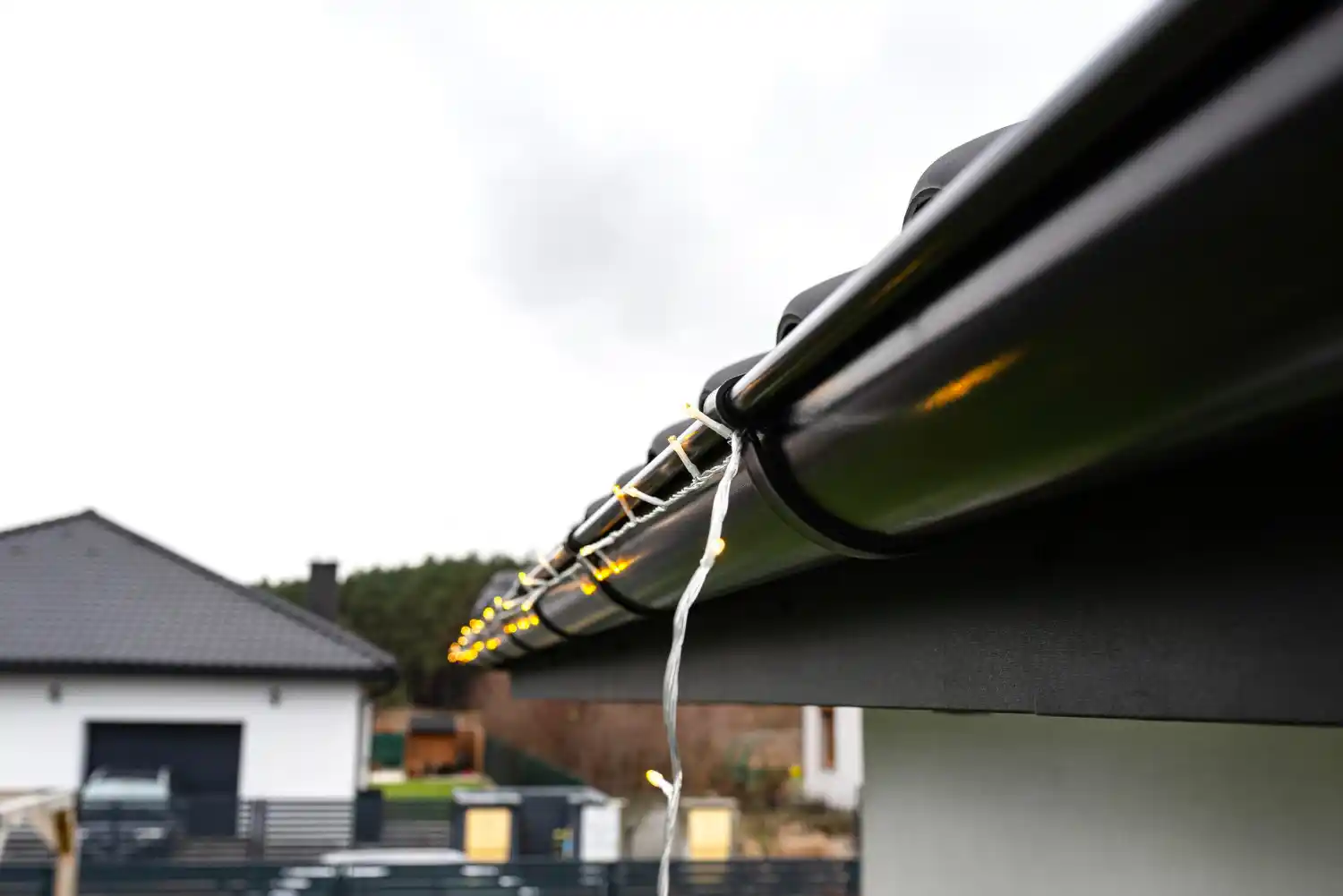 Water leaking from damaged residential gutter during rainfall