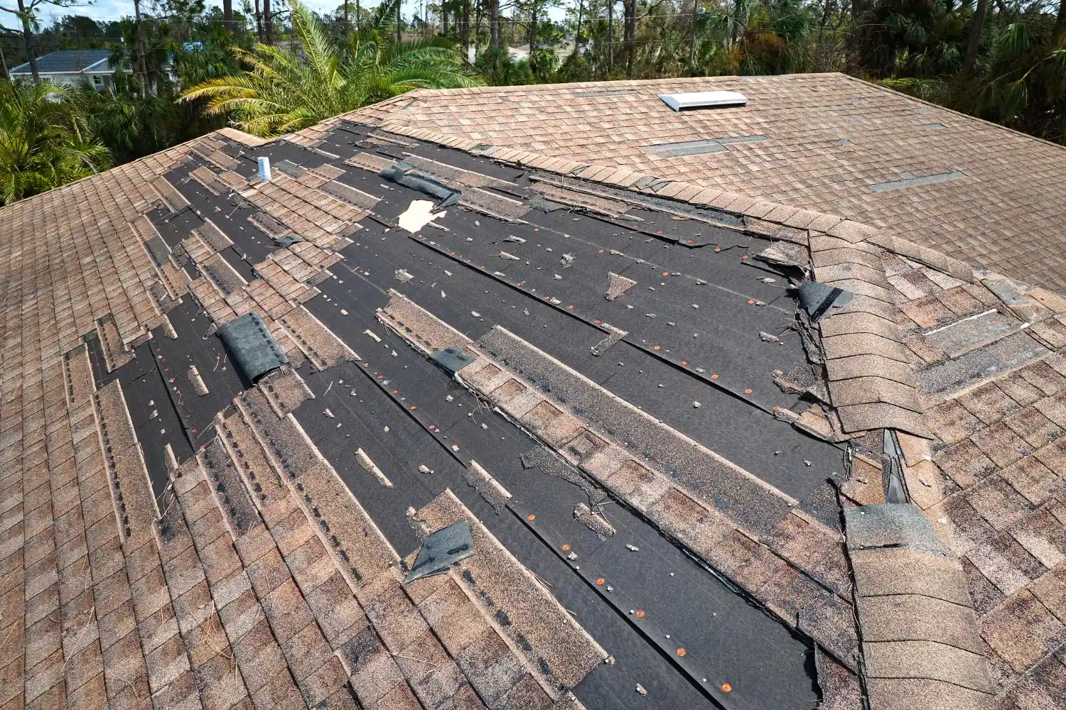 Residential roof damaged by storm requiring urgent repair service